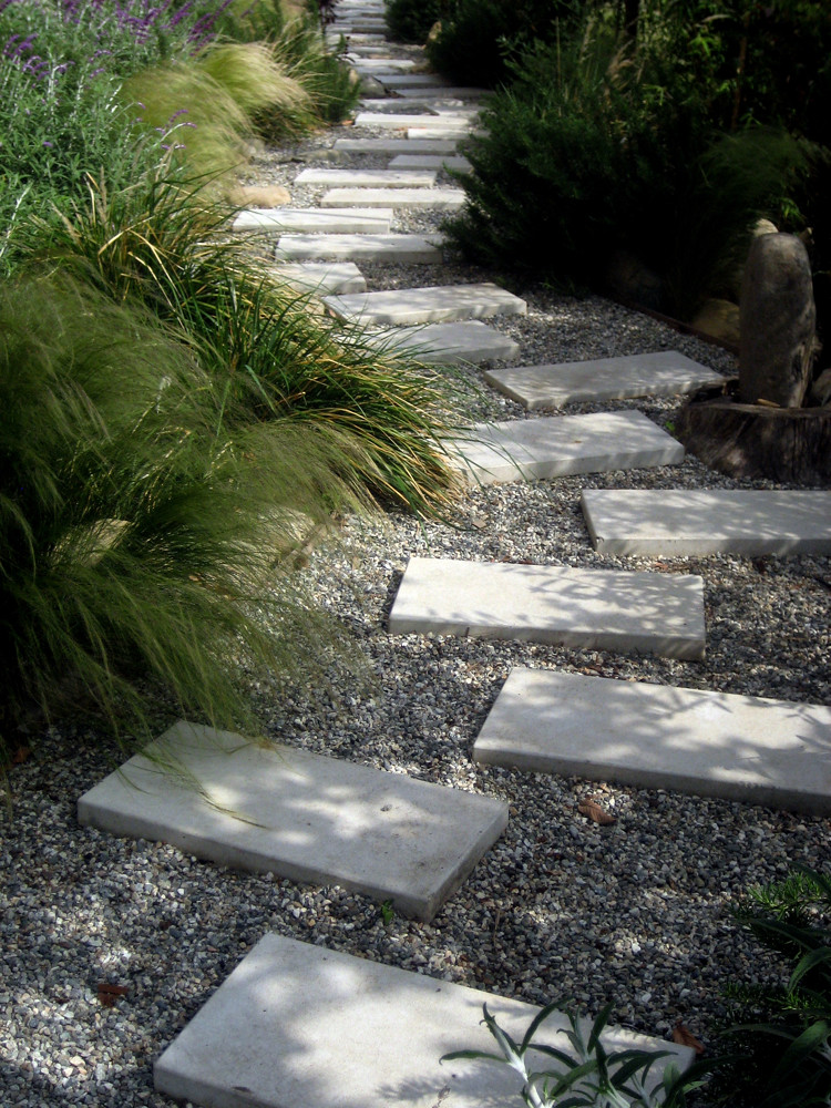 A stepping stone garden path through ornamental grasses and gravel