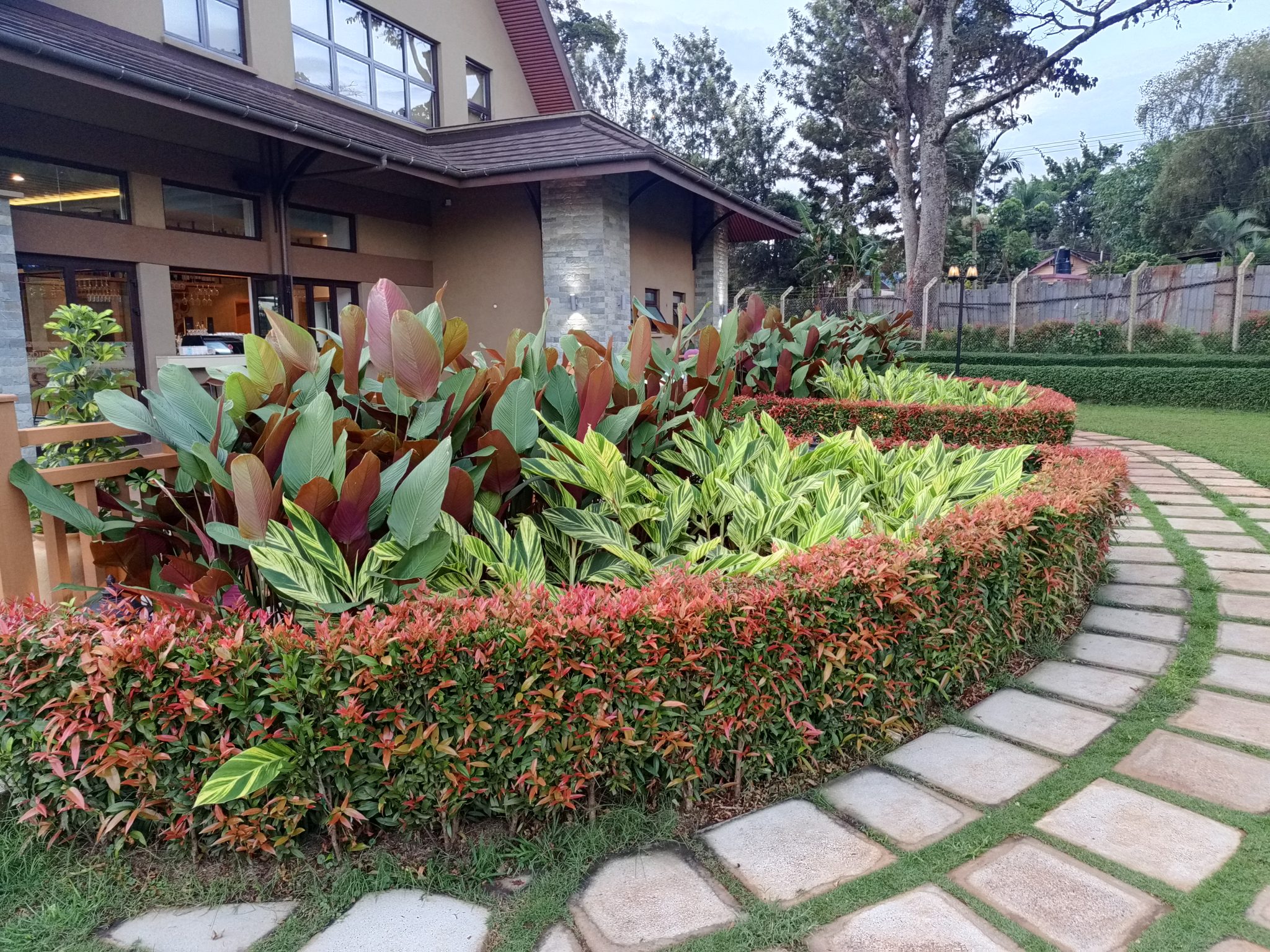 A curved garden bed with layered planting beside a paved stepping stone path